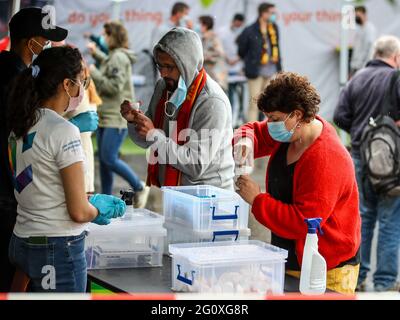 Die Abbildung zeigt die Teilnehmer, die während eines Testevents mit rund 300 Anhängern nach dem Freundschaftsspiel des belgischen Nationalspieles einen Selbsttest machen Stockfoto