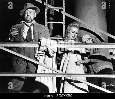 ORSON WELLES am Drehort offen mit Movie Crew Member, das JANET LEIGHS gebrochenen Arm während der Dreharbeiten zu TOUCH OF EVIL verheimlicht 1958 Regisseur / Drehbuch ORSON WELLES nach dem Roman Badge of Evil von Whit Masterson Musik Henry Mancini Universal International Picles (UI) Stockfoto