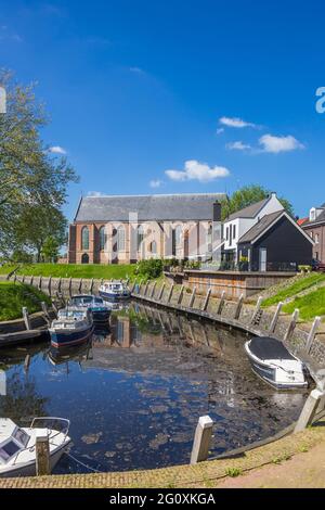 Häuser, Boote und reformierte Kirche am Binnenhafen von Vollenhove, Niederlande Stockfoto