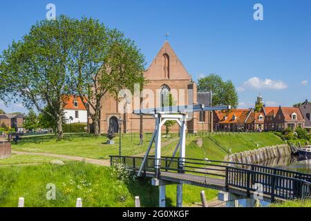 Kleine weiße Brücke und historische Kirche im alten Hafen von Vollenhove, Niederlande Stockfoto