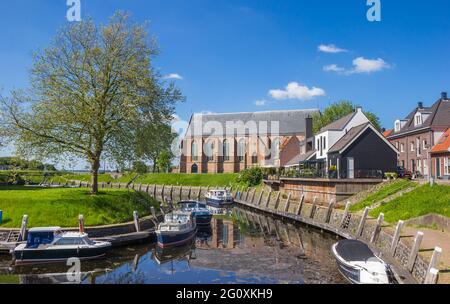 Häuser, Boote und reformierte Kirche am Binnenhafen von Vollenhove, Niederlande Stockfoto