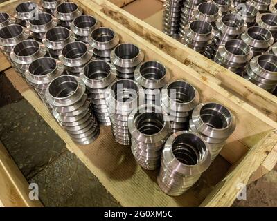 Stapel von Serienfertigung von runden Teilen in Holzkisten im Fabrikgeschoss, Nahaufnahme Stockfoto