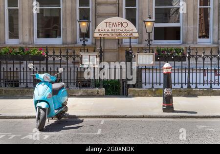 Der Eingang zur Tempio Bar und Restaurant in Temple an einem sonnigen Tag mit einem blauen Vintage Moped draußen. London - 3. Juni 2021 Stockfoto