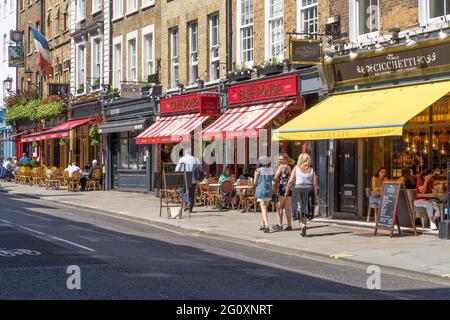 Die belebten Cafés, Restaurants und Bars in der Wellington Street in Covent Garden an einem heißen Sommertag mit Touristen, die draußen essen. London Stockfoto