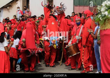 Yare, Venezuela. Juni 2021. Männer, die als Teufel verkleidet sind, tanzen und machen Musik während des Volksfestivals 'Los Diablos Danzantes' (die tanzenden Teufel). Das traditionelle Fest findet seit Jahrzehnten jährlich statt. Kredit: Jesus Vargas/dpa/Alamy Live Nachrichten Stockfoto