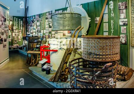 Eine Ausstellung zeigt Arbeiter der Fischfabrik und Ausrüstung, die sie verwendeten, einschließlich riesiger Dampfkessel im Maritime and Seafood Industry Museum, Mai 2 Stockfoto