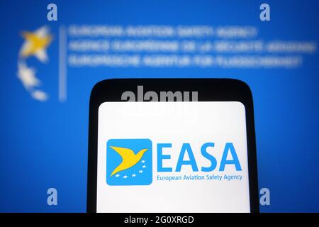 In dieser Abbildung ist das EASA-Logo (European Union Aviation Safety Agency) auf einem Smartphone und einem pc-Bildschirm im Hintergrund zu sehen. Stockfoto