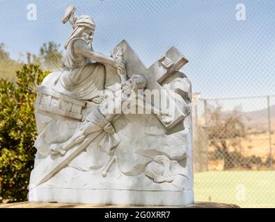 Santa Inez, CA, USA - 3. April 2009: Seminar in San Lorenzo. Station of the Cross Nummer 11 weiße Marmorstatue. Jesus nagelte am Kreuz. Grünes Blatt Stockfoto