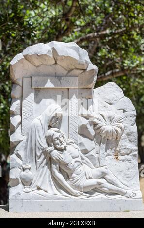 Santa Inez, CA, USA - 3. April 2009: Seminar in San Lorenzo. Station of the Cross Nummer 14 weiße Marmorstatue. Jesus legte in das Grab. Grünes Laub in BA Stockfoto