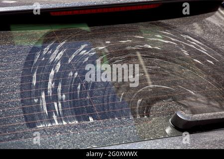 Heckscheibe eines schmutzigen Autos, bedeckt mit einer Schicht von Staub  und Schmutz mit Flecken vom Scheibenwischer, Nahaufnahme Stockfotografie -  Alamy