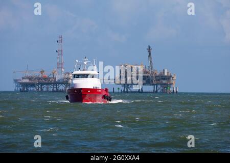 Die Dauphin Island Fähre fährt am 23. Oktober 2020 mit einer Ölbohranlage im Hintergrund zum Dock. Dauphin Island ist eine Barriere-Insel auf dem Stockfoto