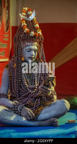 Haridwar, Uttarakhand, Indien 12. April 2021. Indische Heilige in ihrer traditionellen Art von Yog Mudra, meditierend. Schweigend sitzen als Teil der Initiation von neuem Sadhus während Kumbha Mela. Die Naga Sadhus. Stockfoto
