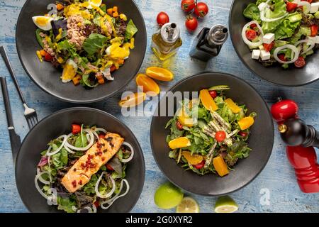 Vier verschiedene Salatsorten werden frisch auf dem Blue Stone-Tisch serviert Stockfoto