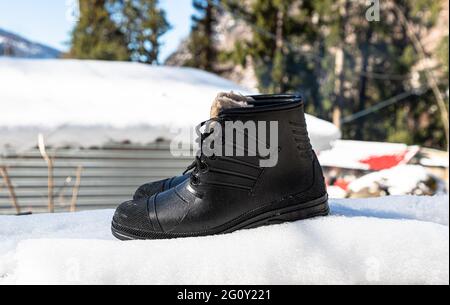 Schwarze Stiefel auf frischem weißen Schnee. Stockfoto