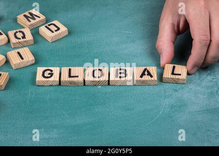 GLOBAL. Hölzerne Buchstaben auf einem grünen Tafelhintergrund. Stockfoto