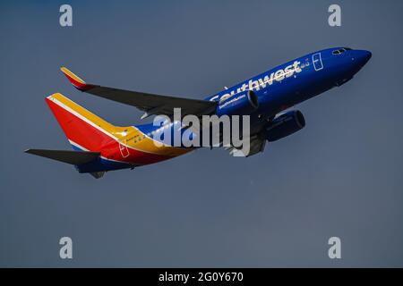 Eine glänzende Boeing 737 bereitet sich darauf vor, direkt nach dem Start vom Flughafen San Jose an die Bank zu gehen. Stockfoto