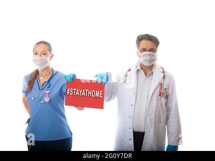 COVID-19 Pandemieärzte und Krankenschwestern halten ein Zeichen, um die Öffentlichkeit aufzufordern, zu Hause zu bleiben, um die Ausbreitung des infektiösen Coronavirus COVID-19 zu stoppen Stockfoto