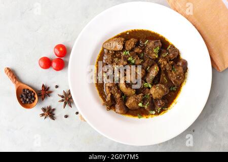 Hähnchenleber-Masala- oder Kaleji-Braten, garniert mit Koriander. Leberbraten ist ein sehr beliebtes nichtvegetarisches indisches Gericht. Hergestellt aus der Hühnerleber. Stockfoto