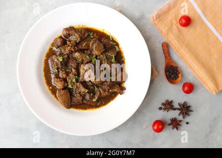 Hähnchenleber-Masala- oder Kaleji-Braten, garniert mit Koriander. Leberbraten ist ein sehr beliebtes nichtvegetarisches indisches Gericht. Hergestellt aus der Hühnerleber. Stockfoto