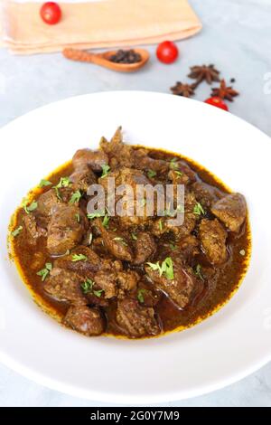 Hähnchenleber-Masala- oder Kaleji-Braten, garniert mit Koriander. Leberbraten ist ein sehr beliebtes nichtvegetarisches indisches Gericht. Hergestellt aus der Hühnerleber. Stockfoto