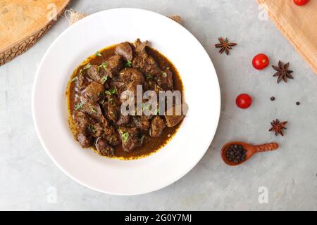 Hähnchenleber-Masala- oder Kaleji-Braten, garniert mit Koriander. Leberbraten ist ein sehr beliebtes nichtvegetarisches indisches Gericht. Hergestellt aus der Hühnerleber. Stockfoto