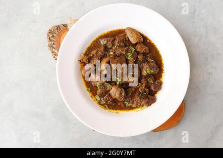 Hähnchenleber-Masala- oder Kaleji-Braten, garniert mit Koriander. Leberbraten ist ein sehr beliebtes nichtvegetarisches indisches Gericht. Hergestellt aus der Hühnerleber. Stockfoto