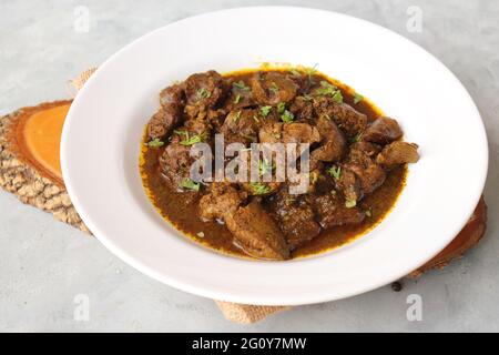 Hähnchenleber-Masala- oder Kaleji-Braten, garniert mit Koriander. Leberbraten ist ein sehr beliebtes nichtvegetarisches indisches Gericht. Hergestellt aus der Hühnerleber. Stockfoto