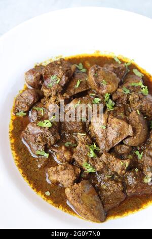 Hähnchenleber-Masala- oder Kaleji-Braten, garniert mit Koriander. Leberbraten ist ein sehr beliebtes nichtvegetarisches indisches Gericht. Hergestellt aus der Hühnerleber. Stockfoto