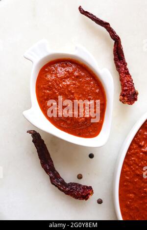 Indisches Essen - Goan Fisch-Urcreme oder einfache rote Kokosnuss Fisch-Urcreme-Masala. Serviert in der fischförmigen Schüssel. Zutaten im Hintergrund mit Platz für Kopien. Stockfoto