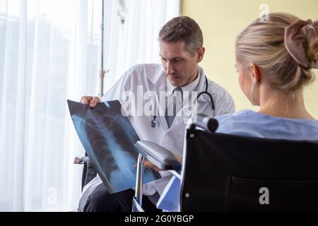 Arzt untersucht Röntgenfilm der Patientin im Krankenhaus. Symptomkonzept für das respiratorische Syndrom oder die virale Lungenentzündung Stockfoto
