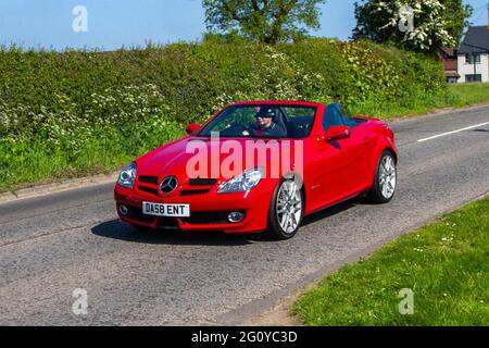 2009 roter Mercedes Benz SLK 200 Kompressor Auto, 1796cc Benzin Roadster Cabrio auf dem Weg zur Capesthorne Hall Classic Car Show in Cheshire, Großbritannien Stockfoto