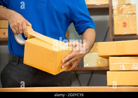 Arbeiter Kurier Mann Verpackung Paketkasten im Büro zur Lieferung Stockfoto