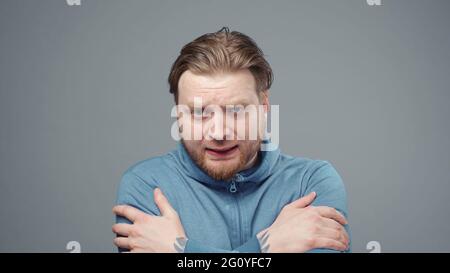Foto eines kalten Mannes in blauem Sweatshirt, Nahaufnahme Stockfoto