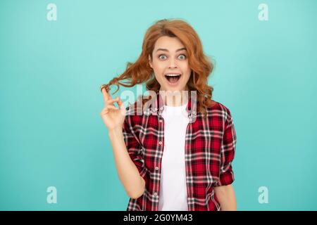 Verblüffte Rothaarige Frau mit lockigem Haar in kariertem Casual Shirt, Mode Stockfoto