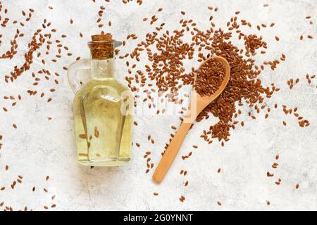 Rohe Leinsamen Öl und Samen mit einem Löffel Draufsicht auf weißem Tisch Stockfoto
