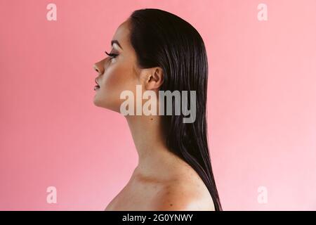 Seitenansicht Nahaufnahme einer Frau mit klarer Haut auf rosa Hintergrund. Make-up zur Verbesserung der natürlichen Schönheit einer Frau. Stockfoto