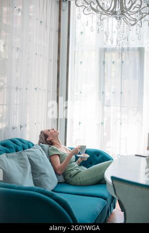 Eine attraktive Frau an einem Tisch in einem Café trinkt Kaffee. Stockfoto