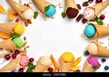 Verschiedene Eiscreme in Zapfen auf weißem Hintergrund. Bunte Eiscreme in verschiedenen Geschmacksrichtungen. Eiscreme mit Nüssen, Früchten und Beeren isoliert. Stockfoto