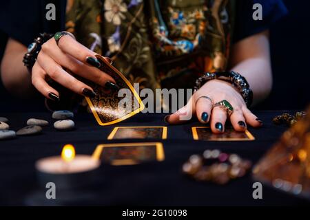 Kartomantie. Wahrsagerei auf Karten. Ein Wahrsager legt Tarot-Karten aus. Nahaufnahme der Hände. Das Konzept der Weissagung, Astrologie und Eoterik. Stockfoto