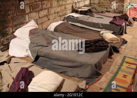 Camp-Betten und Decken im alten Stil in einem Schlafsaal. Stockfoto