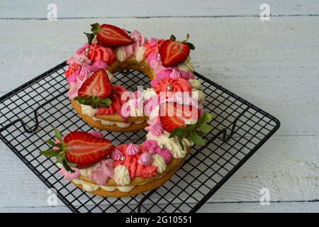 Geburtstagskuchen. Ungewöhnliches modernes Design mit Erdbeeren. Frühling. Postkarte für den Urlaub. Schöner Kuchen in Form der Nummer 9 auf dem Kochen Stockfoto