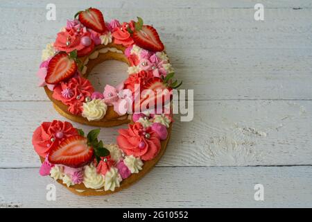 Geburtstagskuchen. Ungewöhnliche Erdbeeren in modernem Design. Frühling. Postkartenurlaub. Glückwünsche sind hell und kreativ. Schöner Kuchen in der Form Stockfoto