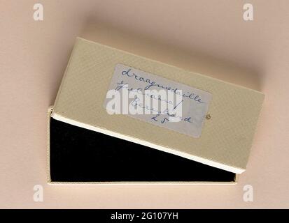 Kasten mit Medaille der fünfundzwanzig Jahre Ehe von Königin Juliana und Prinz Bernhard. Cremefarbener Karton mit einem losen Deckel, auf dem eine Krone und ein Etikett mit Stift bedruckt sind. Auf der Rückseite in Steno Handschrift van Drees. Einlage aus blauem Samt. Stockfoto