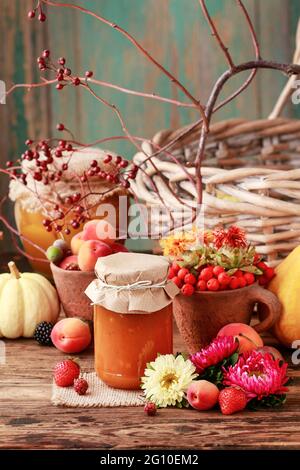 Marmeladen in Gläsern zwischen Obst und Gemüse. Gesunde Ernährung Stockfoto