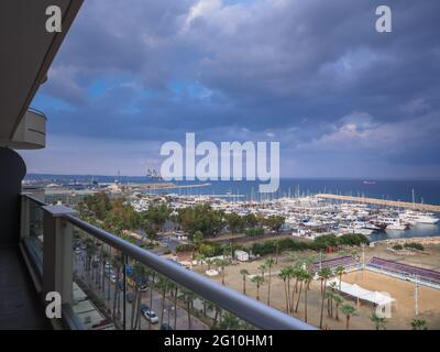 Top Luftbild mit Blick auf Finikoudes Palmenpromenade und Pier mit Yachten in der Nähe des Mittelmeers in Larnaca Stadt. Industrielles Stadtbild. Stockfoto