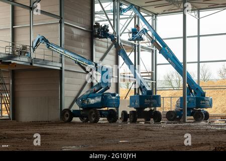 VENLO, NIEDERLANDE - 01. Feb 2018: Drei Luftplattformen mit Ingenieuren auf einer Baustelle. Stockfoto