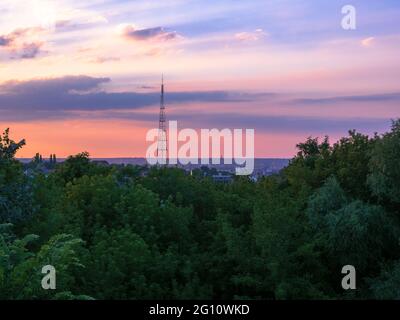 Panoramablick von Kiew (Kiew) Attraktion Peyzazhna Gasse über den Fernsehturm und erstaunlichen Sonnenuntergang über Podil Bezirk mit Spitzen von Gebäuden. Stockfoto