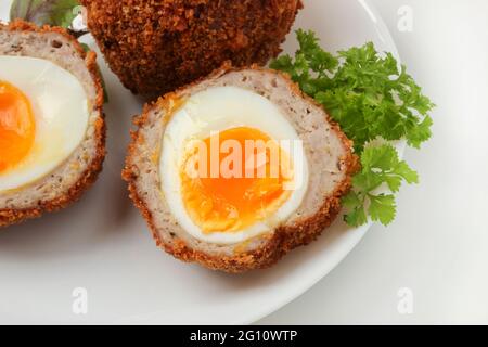 Gekochte schottische Eier auf weißem Porzellanteller aus nächster Nähe Stockfoto