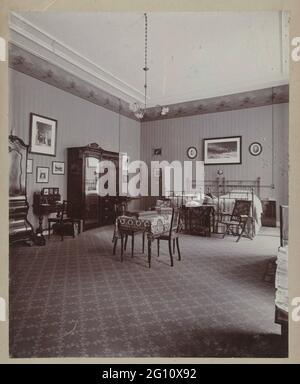 Interieur des Wildbaan, dem Haus des Fotografen in Driebergen. Ein Schlafzimmer mit zwei Betten, ein Leinenschrankschrank und ein Arbeitstisch auf dem Wildlear Rail Estate, mit Fotos und Drucken an der Wand. Stockfoto