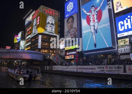 OSAKA, JAPAN - 30. Dez 2019: Osaka, Japan - 1. Dez, 2019: Touristenboot im Dotonbori Kanal und berühmtes Glico Running man Schild in Namba, Osaka. Stockfoto